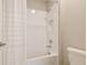 This shower features subway tiles, a bathtub, white shower curtain, and modern fixtures and hardware at 21291 Snowy Orchid Ter, Land O Lakes, FL 34637