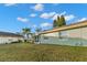 Landscaped backyard with grassy area and a screened patio at 2232 Greenwich Dr # 56, Sun City Center, FL 33573