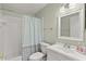 Bright bathroom featuring a white vanity, square mirror, and a shower with a patterned curtain at 2232 Greenwich Dr # 56, Sun City Center, FL 33573