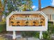 Community entrance sign for Gloucester, featuring a wood design and hummingbird accents at 2232 Greenwich Dr # 56, Sun City Center, FL 33573