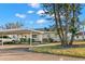 View of a quaint light blue home with a carport and healthy, green landscaping at 2232 Greenwich Dr # 56, Sun City Center, FL 33573