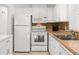 Efficient kitchen featuring white appliances, ample counter space, and mosaic backsplash at 2232 Greenwich Dr # 56, Sun City Center, FL 33573
