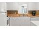 Well-lit kitchen with modern sink, white cabinetry, and a built-in dishwasher at 2232 Greenwich Dr # 56, Sun City Center, FL 33573