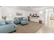 Inviting living room with neutral carpet, blue furniture, and a charming beach-themed artwork at 2232 Greenwich Dr # 56, Sun City Center, FL 33573