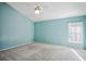 Light teal bedroom with ceiling fan and large window at 28424 Openfield Loop, Wesley Chapel, FL 33543