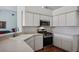 Well-equipped kitchen featuring stainless steel appliances and white cabinets at 28424 Openfield Loop, Wesley Chapel, FL 33543