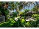 Lush backyard oasis with fire pit and thatch palapa at 3014 Samara Dr, Tampa, FL 33618