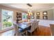 Formal dining room with large windows, hardwood floors, and a rustic table at 3014 Samara Dr, Tampa, FL 33618