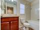 Bathroom with tub, toilet, vanity with wood cabinets, and tiled floor at 31225 Claridge Pl, Wesley Chapel, FL 33543