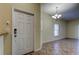 Bright entryway with tiled floor, white door, and chandelier at 31225 Claridge Pl, Wesley Chapel, FL 33543