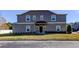 Front view of a two-story townhome with gray siding and landscaping at 31225 Claridge Pl, Wesley Chapel, FL 33543