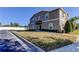 Two-story townhome with gray siding, landscaping, and a paved driveway at 31225 Claridge Pl, Wesley Chapel, FL 33543