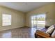 Bright living room with tiled floors, sliding glass door to patio, and a futon at 31225 Claridge Pl, Wesley Chapel, FL 33543