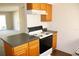 Kitchen features wood cabinets, electric range, and view into living area at 4215 E Bay Dr # 1202C, Clearwater, FL 33764