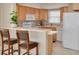 Bright kitchen with light wood cabinets, modern appliances, and breakfast bar at 55 Harbor View Ln # 301, Belleair Bluffs, FL 33770