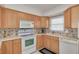 Well-equipped kitchen featuring light wood cabinets and updated appliances at 55 Harbor View Ln # 301, Belleair Bluffs, FL 33770