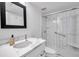 Modern bathroom showcasing a sleek shower, vanity with marble countertop and a framed mirror at 650 Island Way # 106, Clearwater Beach, FL 33767