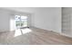 Sunlit living room with wood floors and sliding glass doors to outdoor view at 650 Island Way # 106, Clearwater Beach, FL 33767