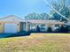 Single-story home with attached one-car garage and landscaping at 712 Gateway Ln, Tampa, FL 33613