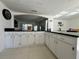 Kitchen with white cabinets, black countertops, and an arched opening to another room at 712 Gateway Ln, Tampa, FL 33613