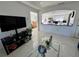 Living area with entertainment center, view of the kitchen, and polished tile floor at 712 Gateway Ln, Tampa, FL 33613