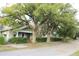 Charming light green house with mature trees and a well-maintained front yard at 908 E 17Th Ave, Tampa, FL 33605