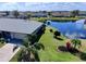 Lush landscaping, paver driveway, and lake view enhance this aerial view of the property at 1506 Bentwood Dr, Sun City Center, FL 33573