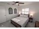 Cozy bedroom featuring a bed with wood trim, ceiling fan, carpet flooring and a sunny window at 1506 Bentwood Dr, Sun City Center, FL 33573