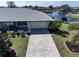 Inviting front of home with manicured lawn, stone paver driveway, and view of the adjacent pond at 1506 Bentwood Dr, Sun City Center, FL 33573
