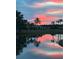 Picturesque pond view reflecting a stunning sunset, surrounded by trees and lush landscaping at 1506 Bentwood Dr, Sun City Center, FL 33573