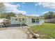 Light green house exterior with covered patio and landscaping at 1514 Nelson Ave, Clearwater, FL 33755