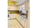 White kitchen with double sink, tile flooring, and window at 1660 S Lake Ave # 1, Clearwater, FL 33756