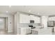 Modern kitchen with white cabinets, stainless steel appliances, and a center island at 17901 Solstice Ave, Venice, FL 34293