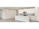 Open-concept kitchen featuring an island, stainless steel appliances, and a white design at 17901 Solstice Ave, Venice, FL 34293