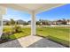 View from a covered patio showcasing the well-manicured lawn and the community's charming streetscape at 17901 Solstice Ave, Venice, FL 34293