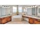 Double vanity bathroom with granite countertops, a corner soaking tub, and ample light at 18014 Cozumel Isle Dr, Tampa, FL 33647