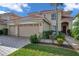 Two-story house with a two-car garage, landscaping, and a walkway at 18014 Cozumel Isle Dr, Tampa, FL 33647
