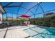 Screened patio with pool, outdoor dining set, and a red umbrella at 3957 Epic Cv, Land O Lakes, FL 34638