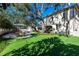 A beautiful green backyard area with mature trees and an outdoor dining area perfect for entertaining guests at 4518 W Rosemere Rd, Tampa, FL 33609