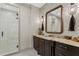 Modern bathroom with a glass-enclosed shower, stylish vanity, and unique mirror at 4518 W Rosemere Rd, Tampa, FL 33609