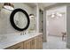 Elegant bathroom boasts patterned walls, round mirror, and modern fixtures, creating a stylish and inviting space at 4518 W Rosemere Rd, Tampa, FL 33609