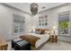 Comfortable bedroom with a decorative chandelier, neutral tones, and natural light at 4518 W Rosemere Rd, Tampa, FL 33609