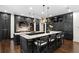 Spacious kitchen featuring dark cabinets, granite countertops, and modern lighting fixtures over the islands at 4518 W Rosemere Rd, Tampa, FL 33609