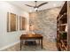 Home office with exposed brick wall, wood desk, and built-in shelving at 4587 Almada Ln, Wesley Chapel, FL 33543