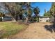 House with gravel driveway, mature trees, and partially visible garage at 505 80Th Ave, St Pete Beach, FL 33706