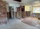 Open-concept living room with brick fireplace and view into another room at 505 80Th Ave, St Pete Beach, FL 33706