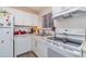 White kitchen with white appliances and subway tile backsplash at 5916 Canal Dr # J35, Bradenton, FL 34207