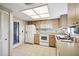 Galley kitchen with white appliances and light wood cabinets at 6474 Pine Meadows Dr, Spring Hill, FL 34606