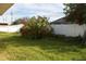 Grass yard with a white vinyl fence and bougainvillea bush at 6760 11Th N Ave, St Petersburg, FL 33710