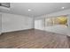 Large finished basement with sliding doors and wood-look floors at 9800 Mendel Dr, New Port Richey, FL 34654